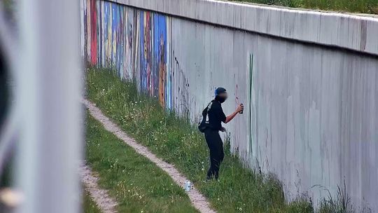 wandal podczas niszczenia antywojennego muralu w Gdańsku