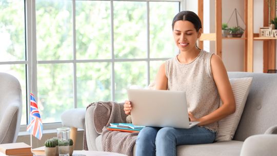 kobieta z laptopem na kolanach, zdjęcie ilustracyjne