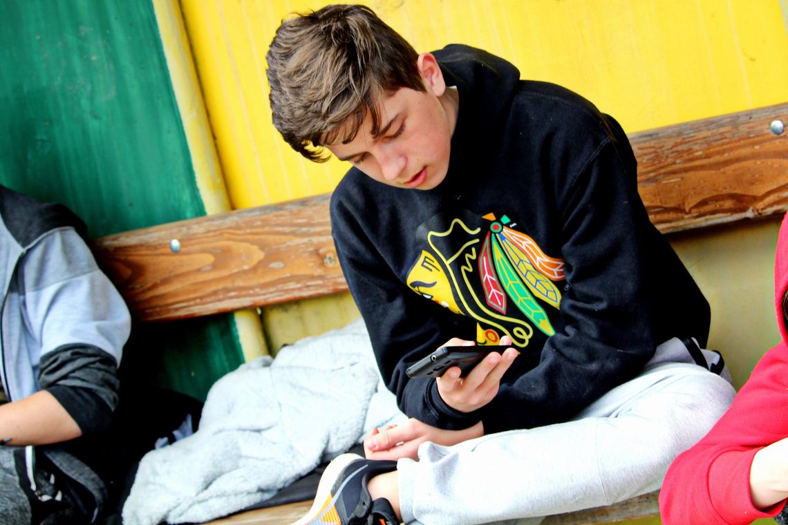 chłopak z telefonem, zakaz komórek w szkołach