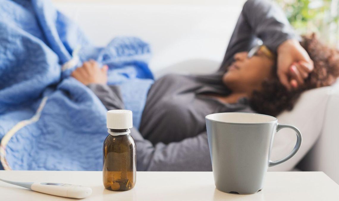 chora kobieta na kanapie, zdjęcie ilustracyjne