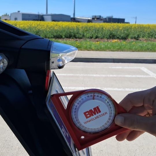 policjanci ze Słupska używają kątomierzy kołowych do pomiaru odgięć tablic rejestracyjnych w motocyklach