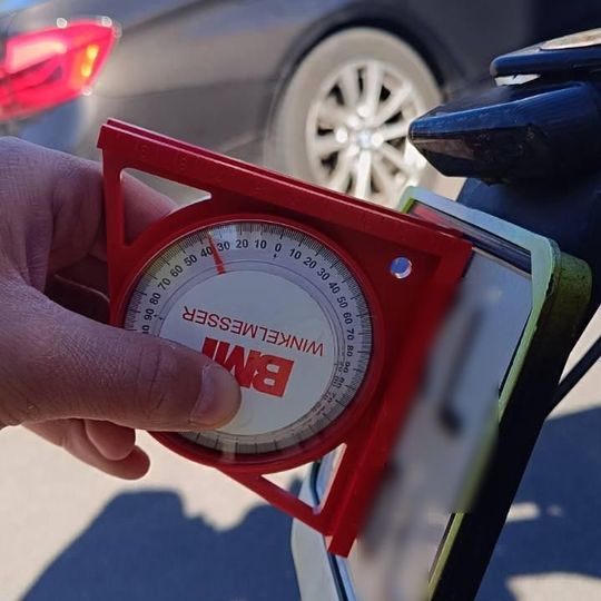 policjanci ze Słupska używają kątomierzy kołowych do pomiaru odgięć tablic rejestracyjnych w motocyklach