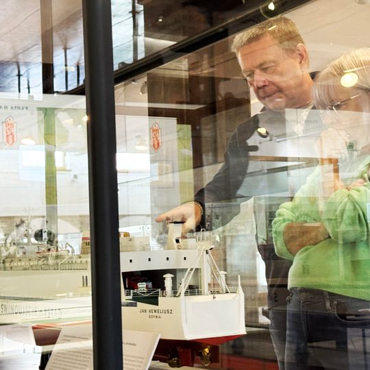 Grzegorz Sudwoj wraz z żoną na tle modelu promu M/F „Jan Heweliusz” ze zbiorów Narodowego Muzeum Morskiego w Gdańsku