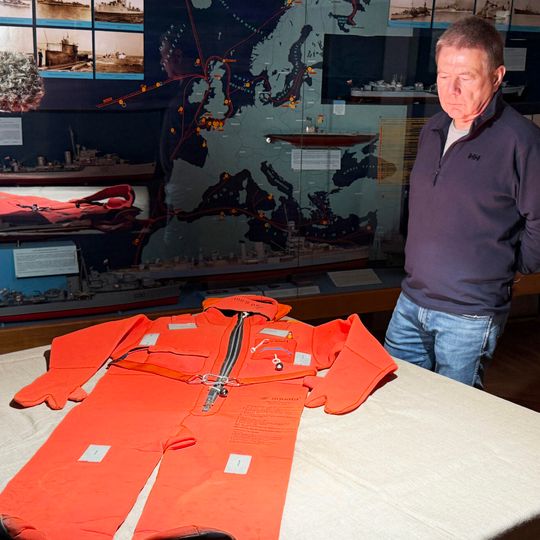 Grzegorz Sudwoj przy kombinezonie ratunkowym podarowanym Narodowemu Muzeum Morskiemu w Gdańsku