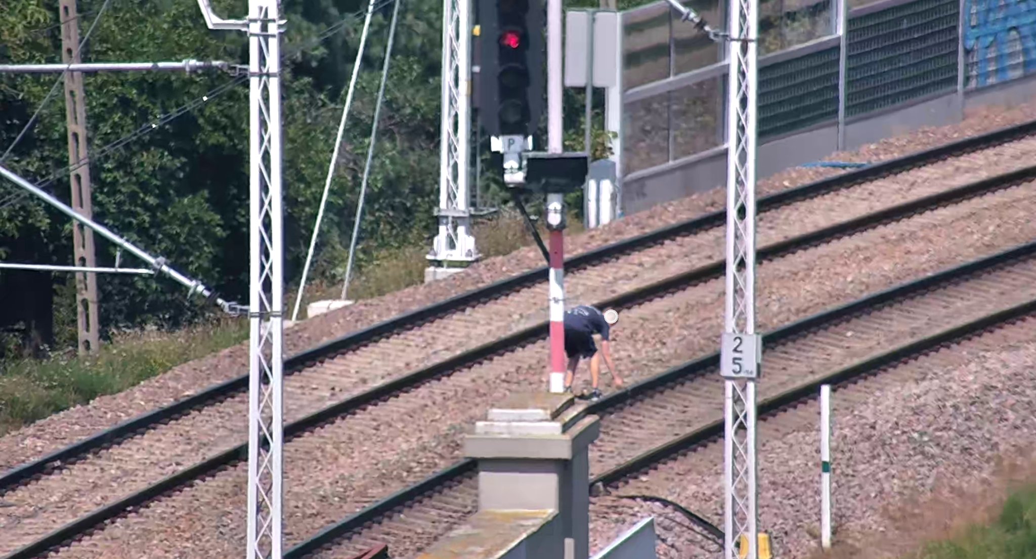 jeden z nastolatków układających kamienie na torach PKM